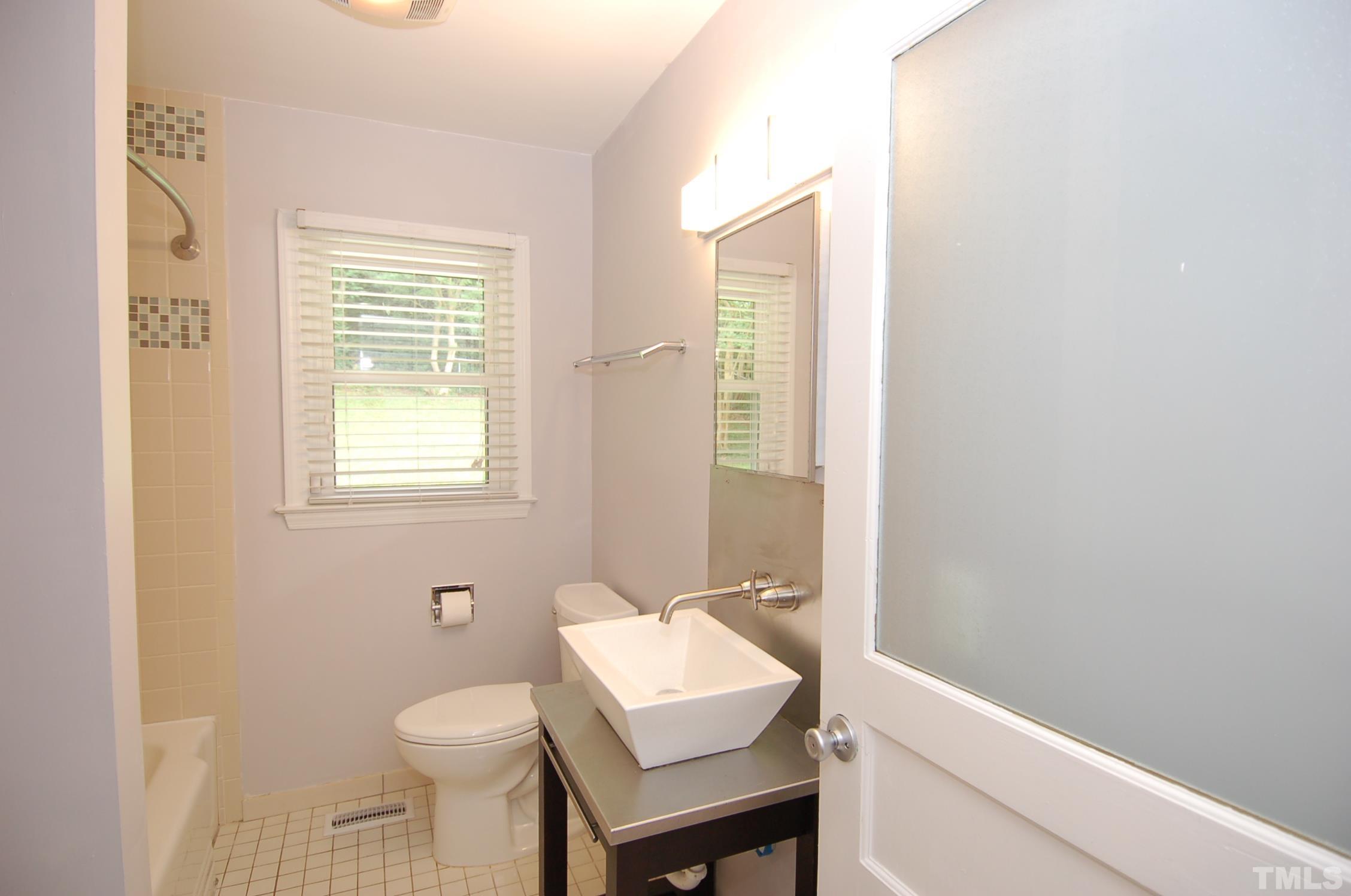 3105 Brentwood Road Raleigh, NC 27604 - Photo 8 of 14 a bathroom with a sink toilet and a mirror