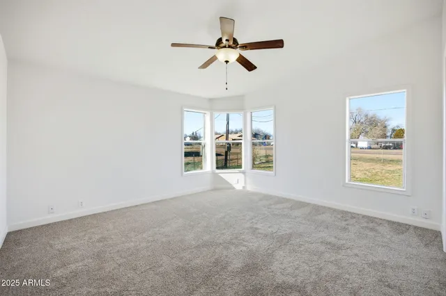 a view of a livingroom with a ceiling fan and window