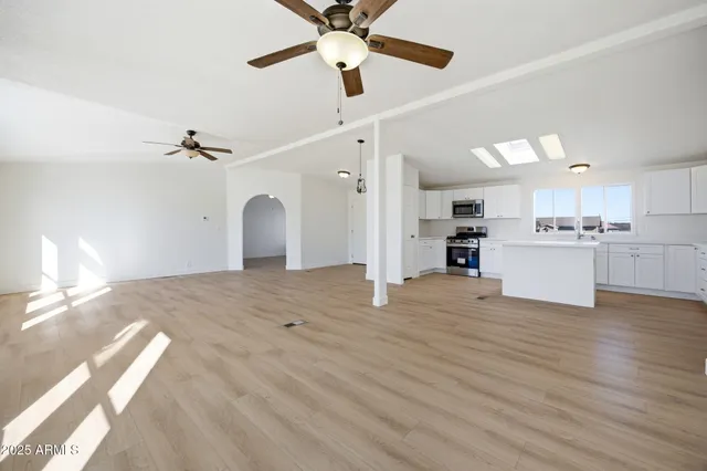 a view of a kitchen with a sink hardwood floor and a ceiling fan