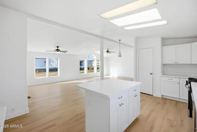 a kitchen with a stove a sink and dishwasher with wooden floor