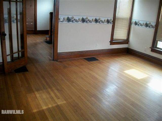 102 Washington Street Ridott, IL 61067 - Photo 4 of 11 an empty room with wooden floor and windows