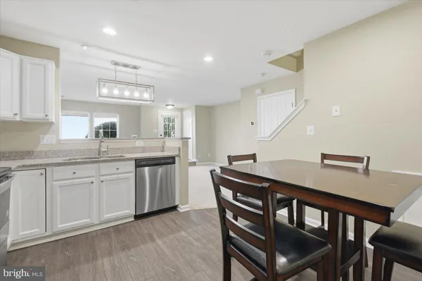 a kitchen with a dining table chairs and white cabinets