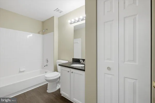 a bathroom with a granite countertop sink a toilet and shower