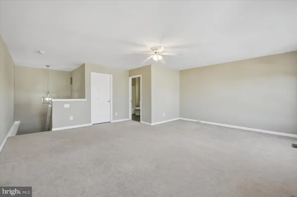 a view of a big room with windows and chandelier fan