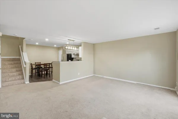 an empty room with kitchen view and a sink