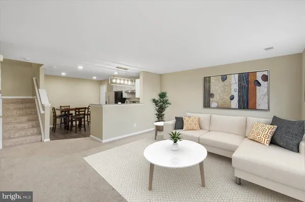 a living room with furniture and a dining table with kitchen view