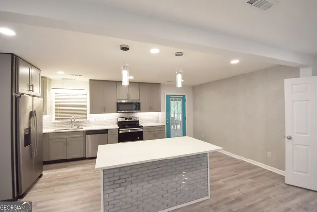 a kitchen with stainless steel appliances granite countertop a refrigerator stove top oven and sink