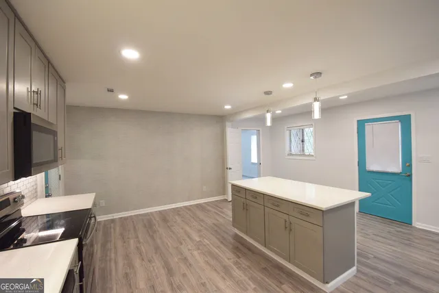 en empty room with windows and chandelier fan