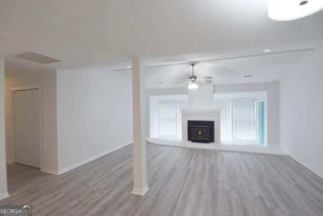 a view of an empty room and chandelier fan