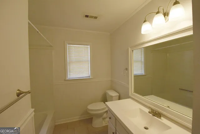 an empty room with fan and windows