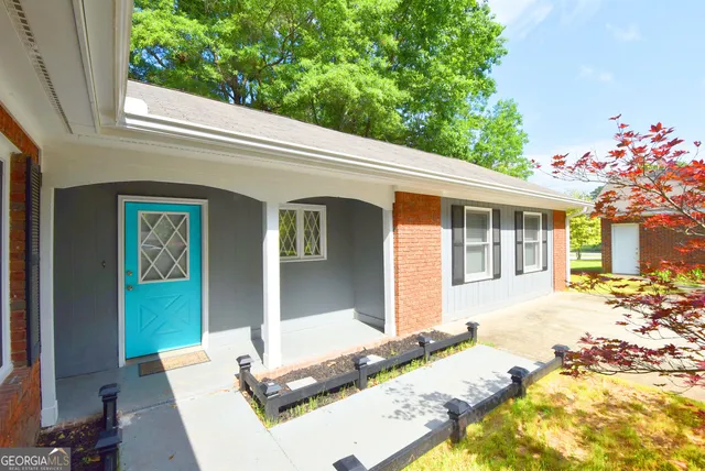 a front view of a house with a garden and trees