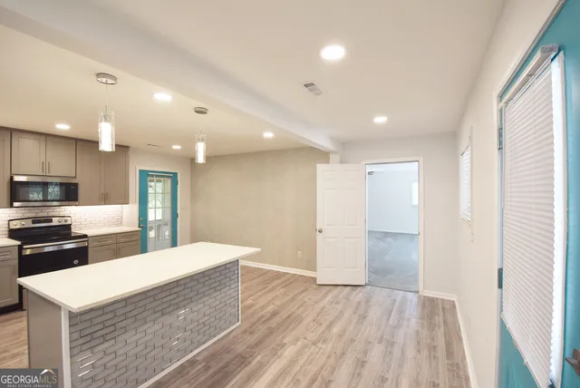 a large kitchen with a sink and a stove top oven
