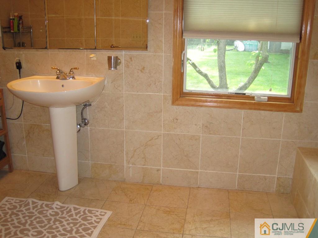 26 Richard Road Edison, NJ 08820 - Photo 13 of 18 a bathroom with a sink a window and shower