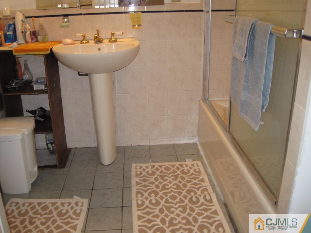 26 Richard Road Edison, NJ 08820 - Photo 15 of 18 a bathroom with a sink a toilet a mirror and shower