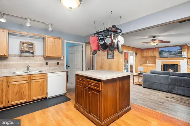 a kitchen that has a lot of cabinets in it and wooden floor