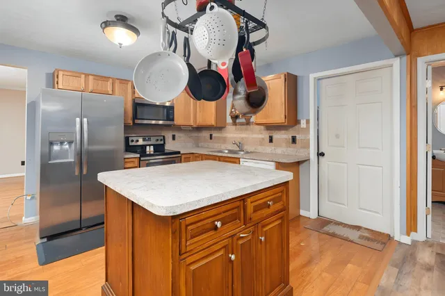 a kitchen with stainless steel appliances granite countertop a sink and a refrigerator