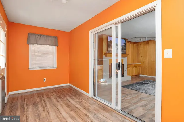 a view of a hallway with wooden floor and a bathroom