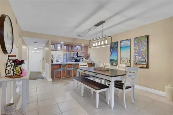 a dining hall with stainless steel appliances granite countertop a table and chairs in it