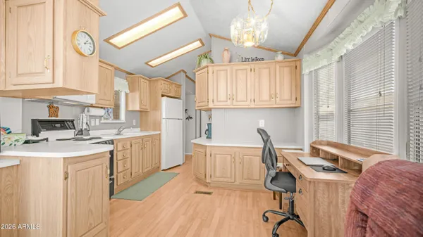 a kitchen with stainless steel appliances granite countertop a stove a sink and white cabinets with wooden floors