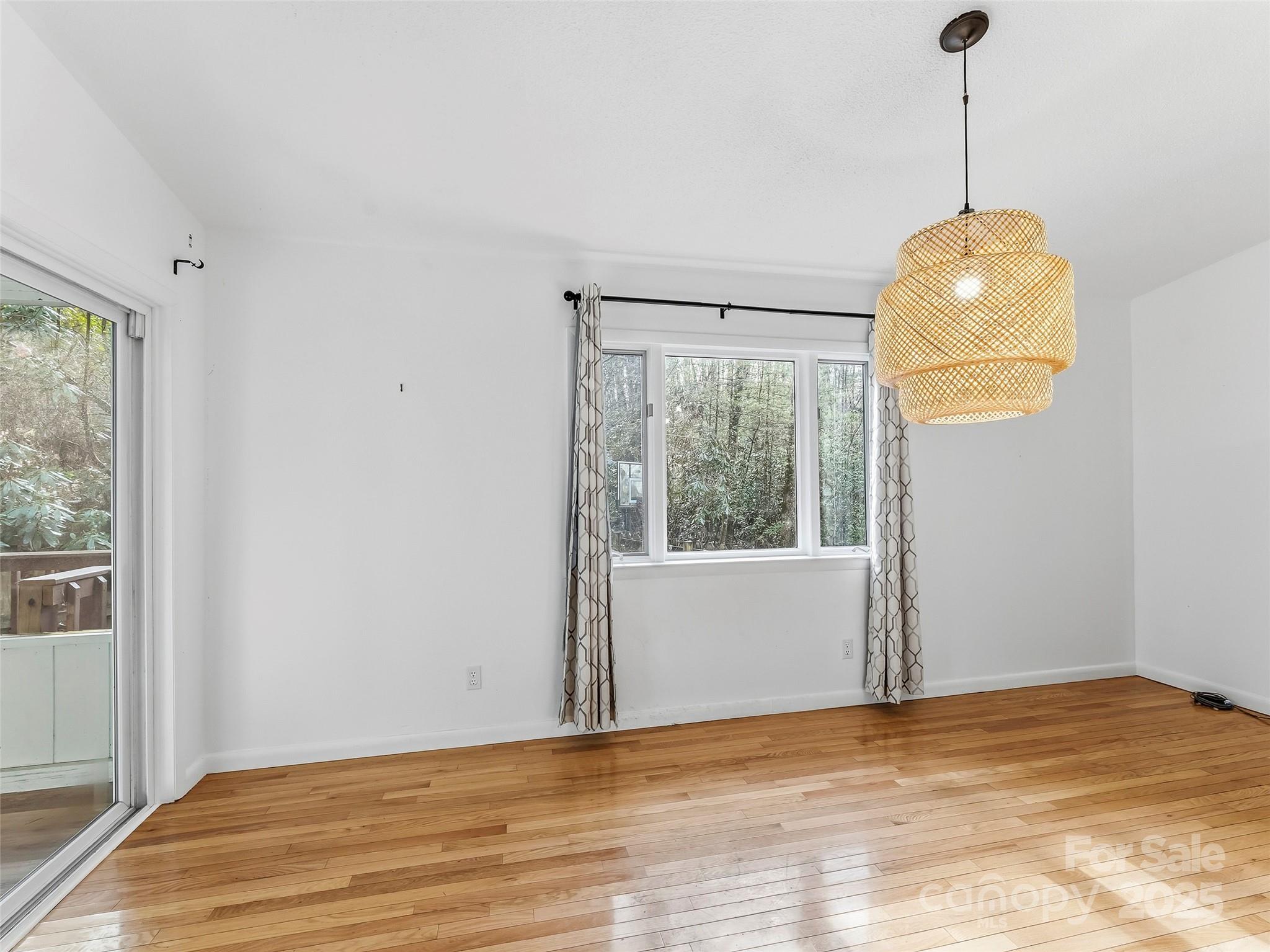 27 Spring Valley Road Pisgah Forest, NC 28768 - Photo 11 of 37 a view of empty room with wooden floor and fan