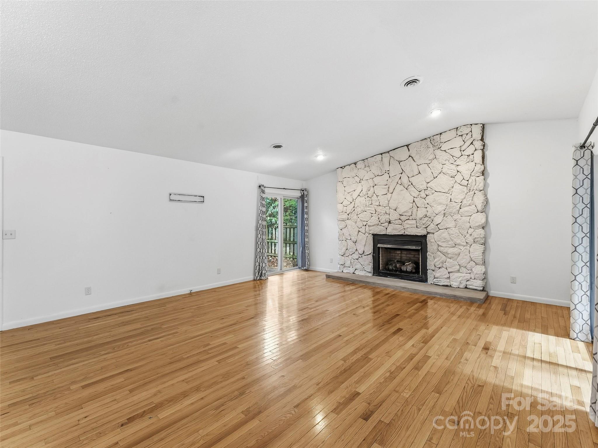 27 Spring Valley Road Pisgah Forest, NC 28768 - Photo 13 of 37 a view of empty room with wooden floor and fireplace