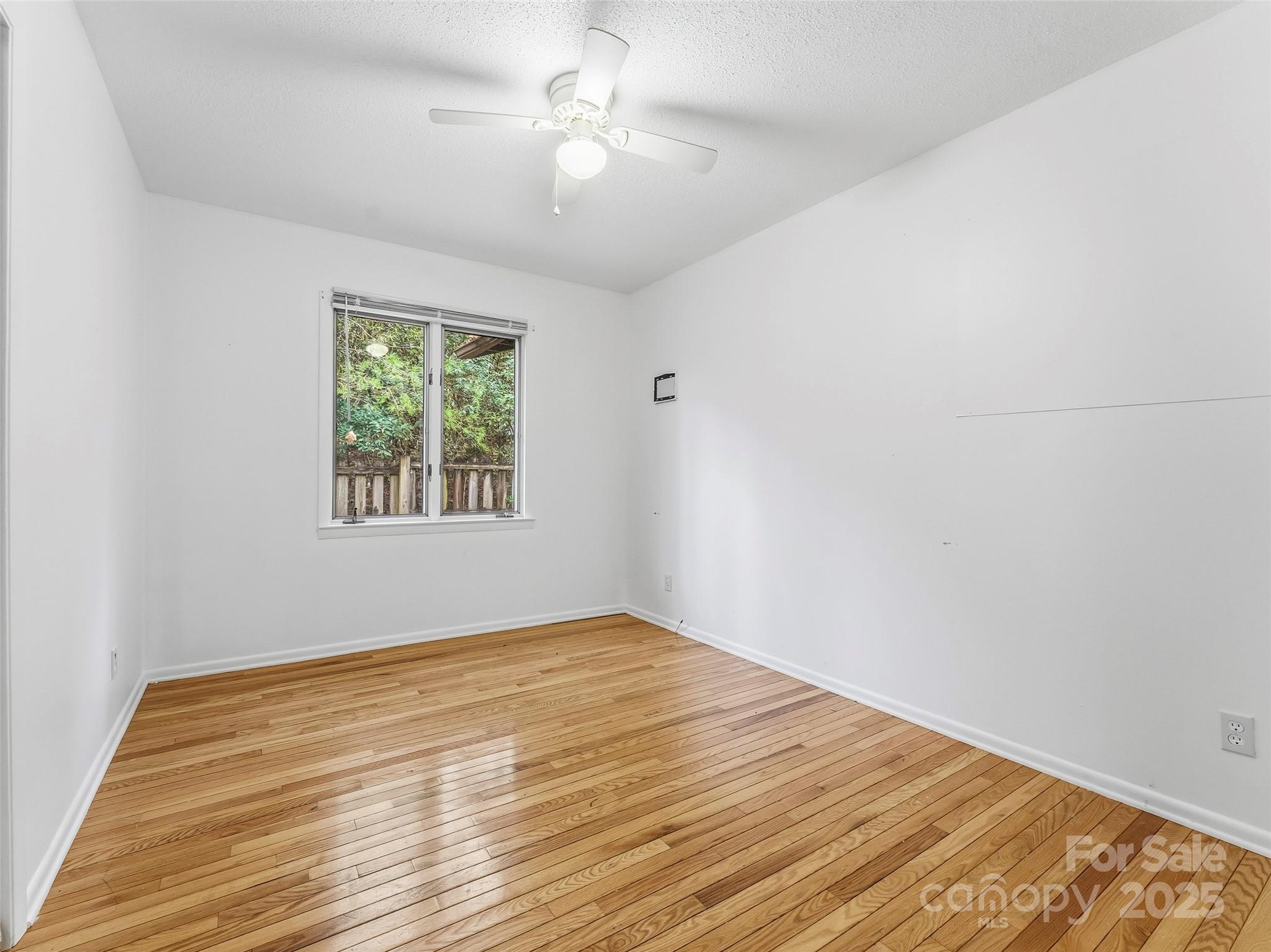 27 Spring Valley Road Pisgah Forest, NC 28768 - Photo 17 of 37 wooden floor in an empty room with a window