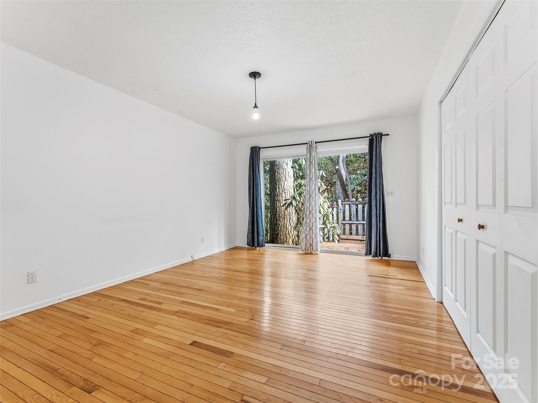 27 Spring Valley Road Pisgah Forest, NC 28768 - Photo 22 of 37 a view of an empty room with wooden floor and a window