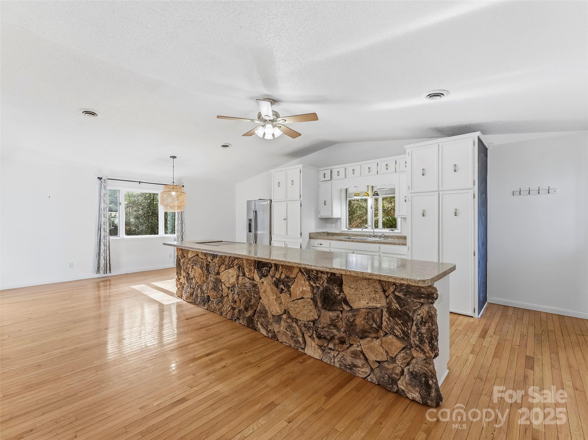 27 Spring Valley Road Pisgah Forest, NC 28768 - Photo 5 of 37 a living room with wooden floors and a ceiling fan