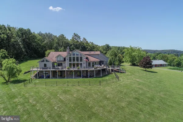 an aerial view of residential house with outdoor space and trees all around
