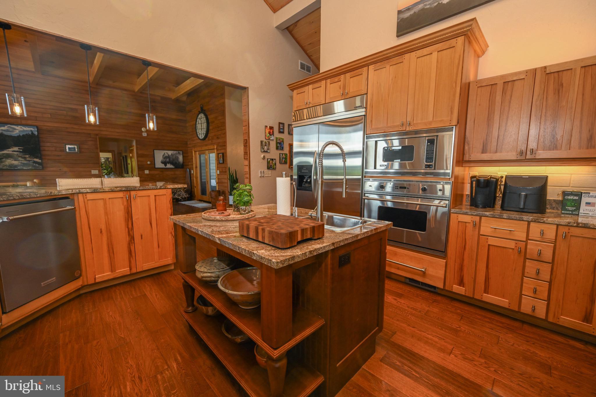 2325 Accident Friendsville Road Accident, MD 21520 - Photo 41 of 107 a kitchen with stainless steel appliances granite countertop a stove a refrigerator and a wooden cabinets
