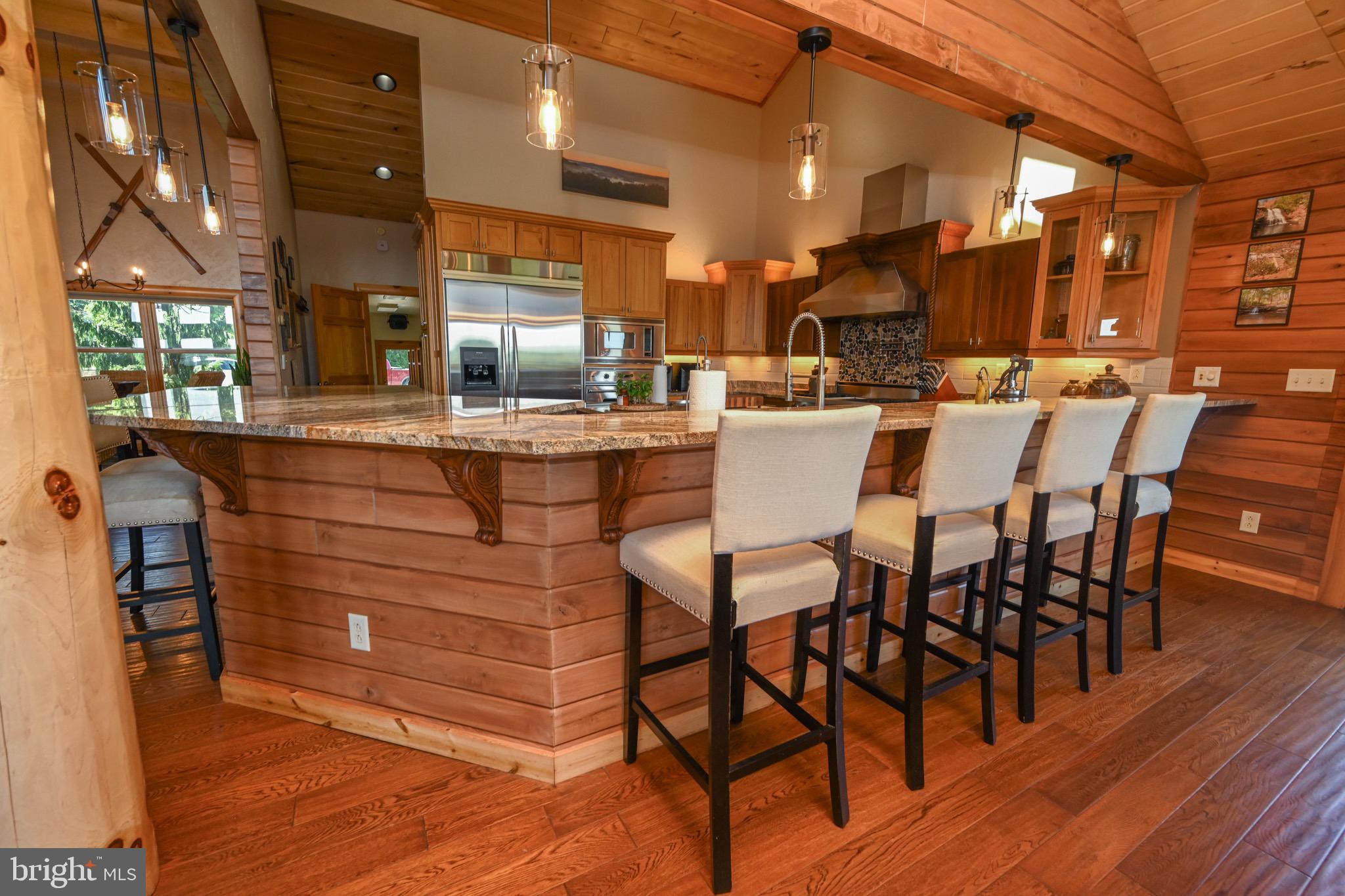 2325 Accident Friendsville Road Accident, MD 21520 - Photo 47 of 107 a dining hall with stainless steel appliances kitchen island granite countertop a table chairs and a wooden floor