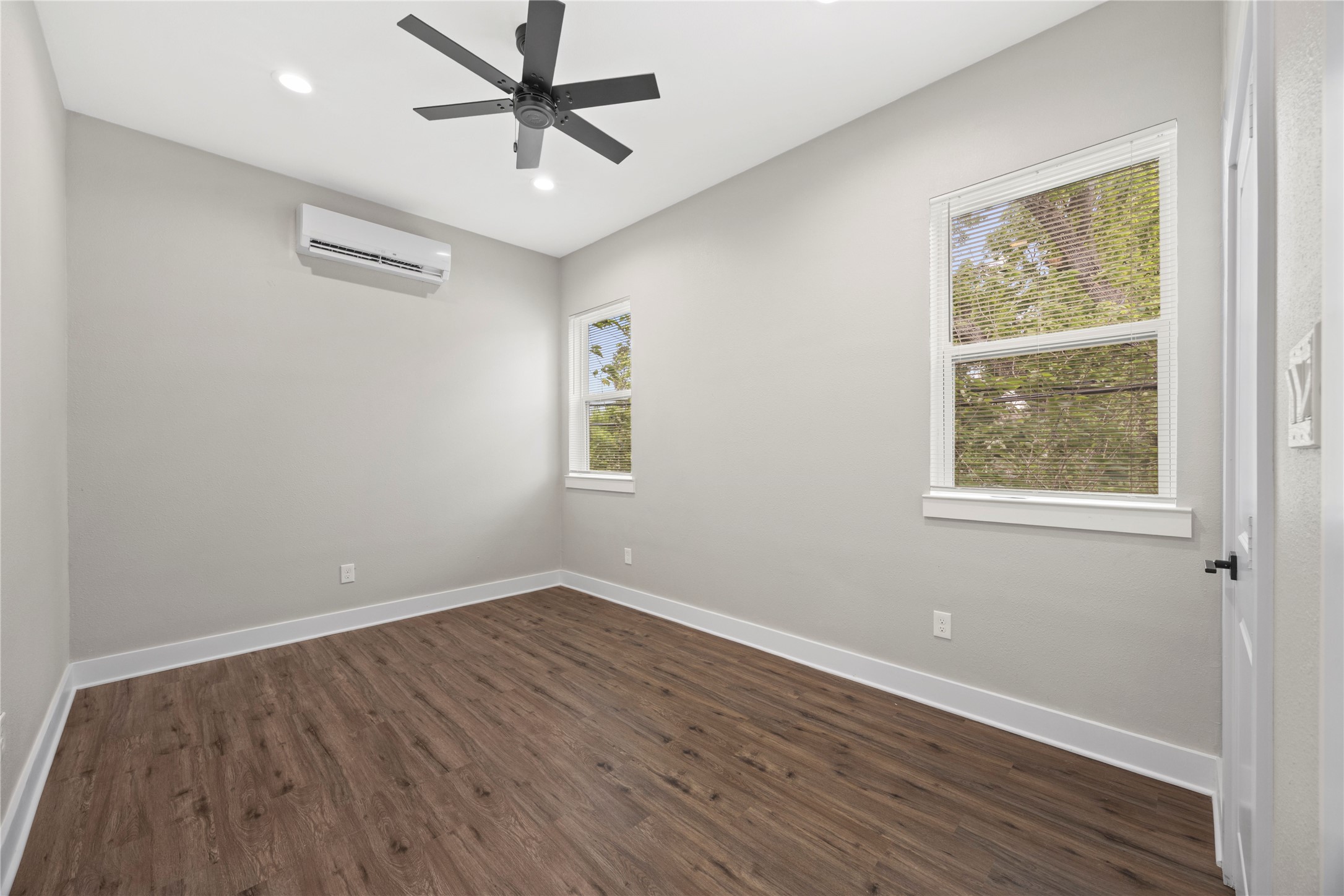 4384 Fiesta Lane Houston, TX 77004 - Photo 4 of 11 an empty room with wooden floor ceiling fan and windows