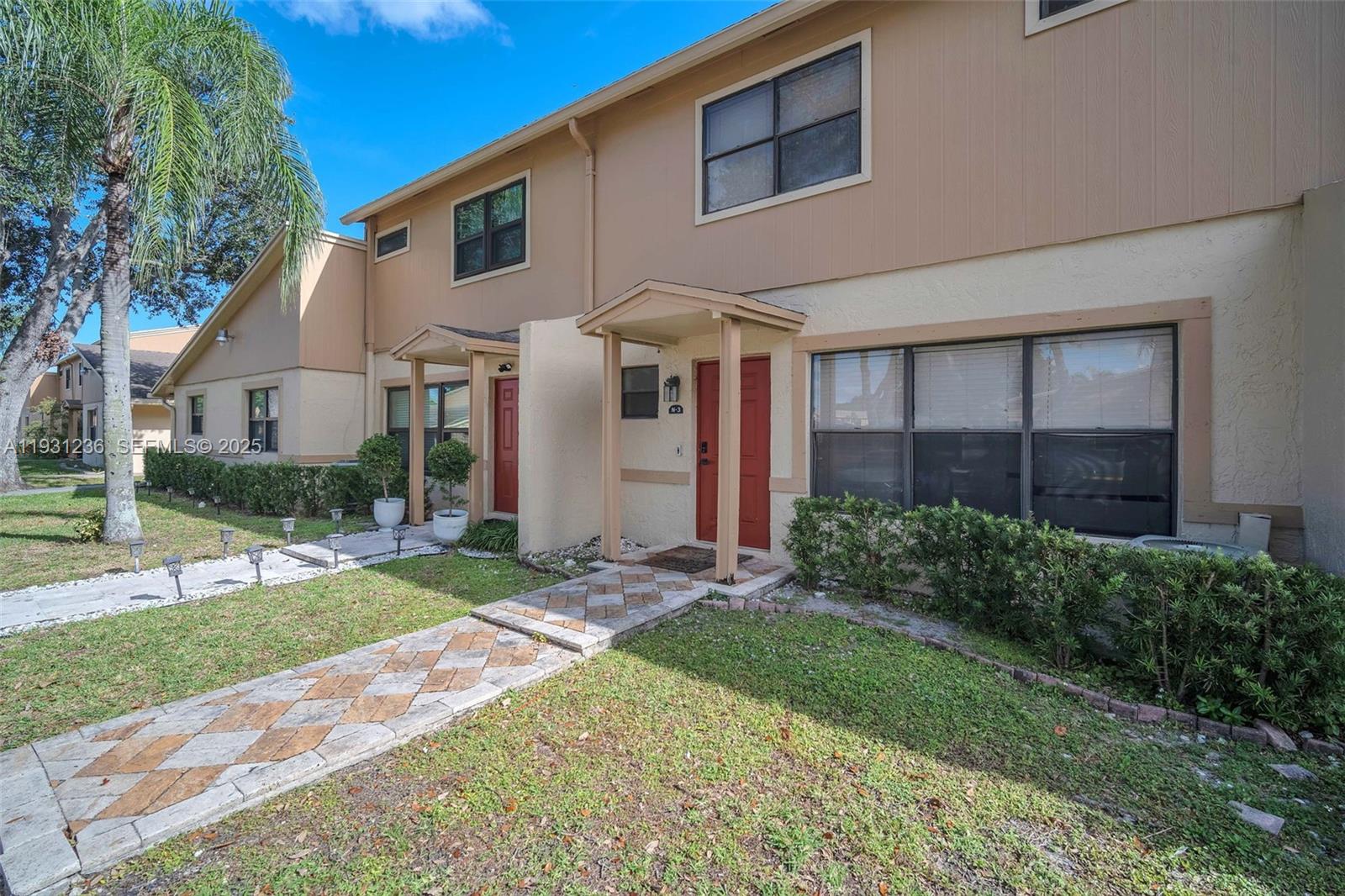 3370 Beau Rivage Drive, Unit 3N Pompano Beach, FL 33064 - Photo 2 of 38 a view of a white house next to a yard and large trees