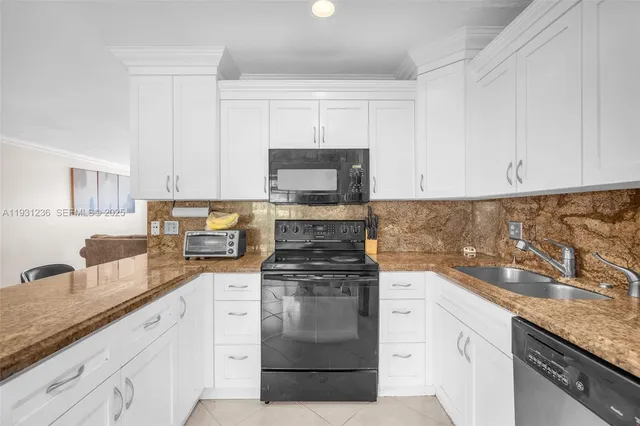 a kitchen with granite countertop white cabinets and stainless steel appliances