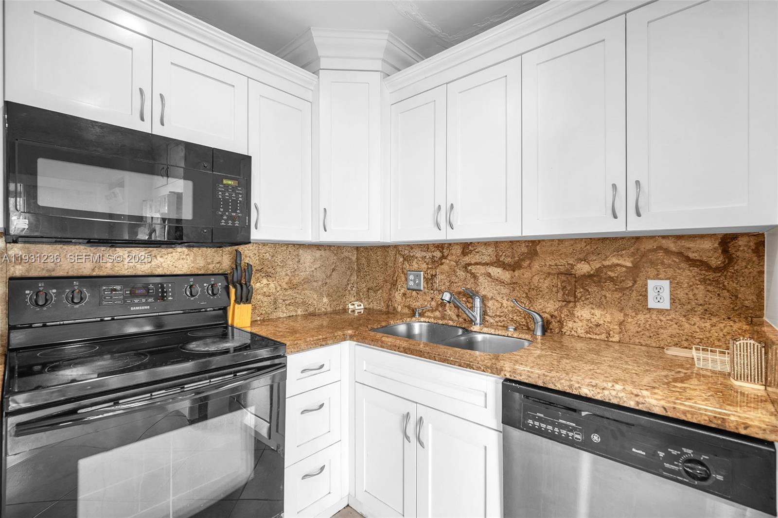 3370 Beau Rivage Drive, Unit 3N Pompano Beach, FL 33064 - Photo 22 of 38 a kitchen with granite countertop white cabinets and stainless steel appliances