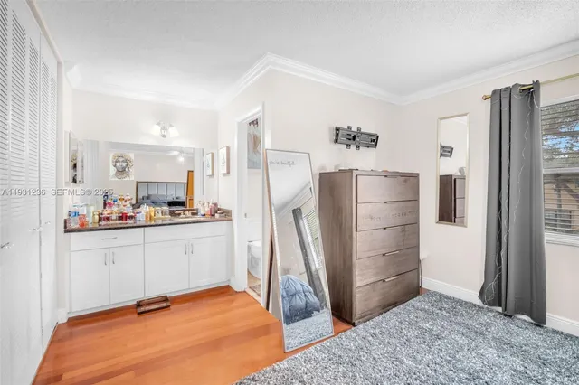 a room with a refrigerator and a dresser