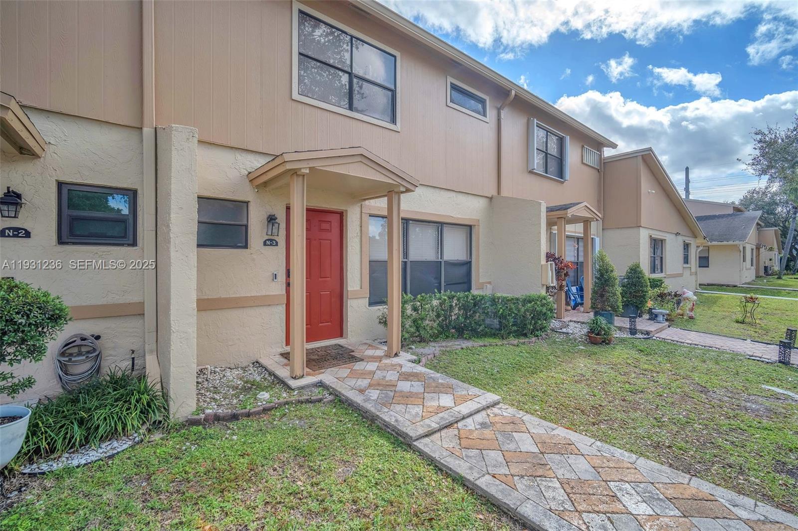 3370 Beau Rivage Drive, Unit 3N Pompano Beach, FL 33064 - Photo 3 of 38 a front view of a house with a yard and garage