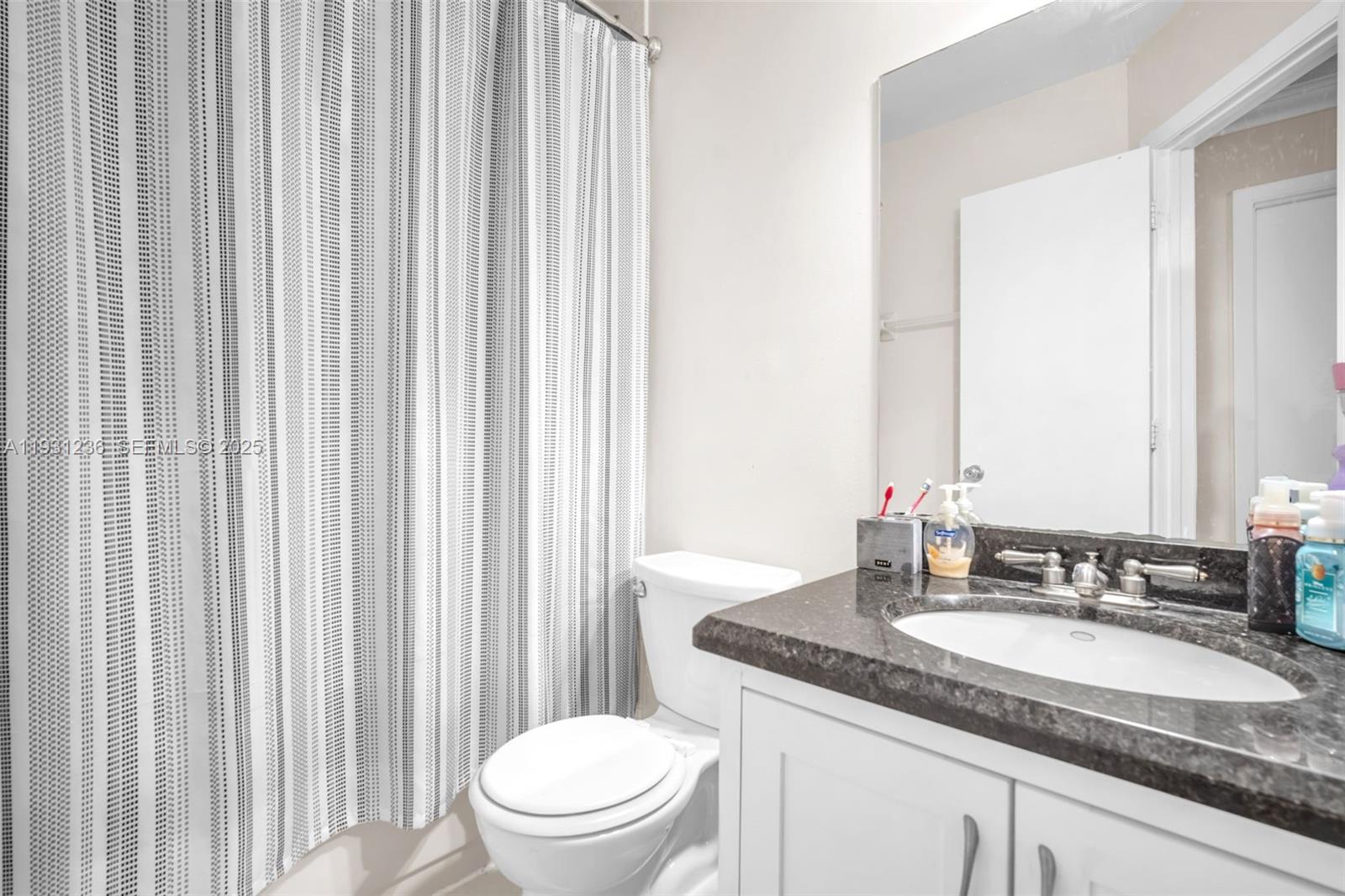 3370 Beau Rivage Drive, Unit 3N Pompano Beach, FL 33064 - Photo 32 of 38 a bathroom with a granite countertop sink and a mirror