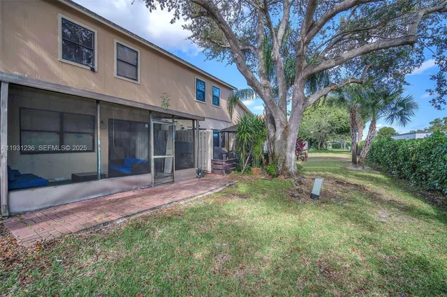 a view of a yard in front of a house with large tree