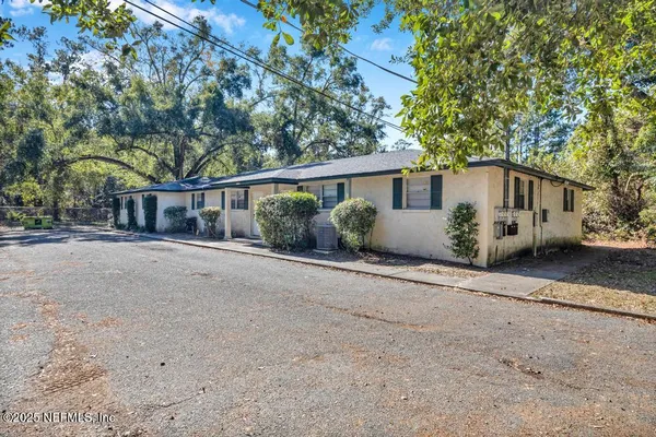 a white house with a tree in front of it