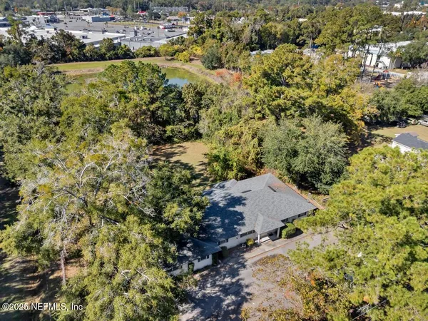 an aerial view of residential house with space and trees all around