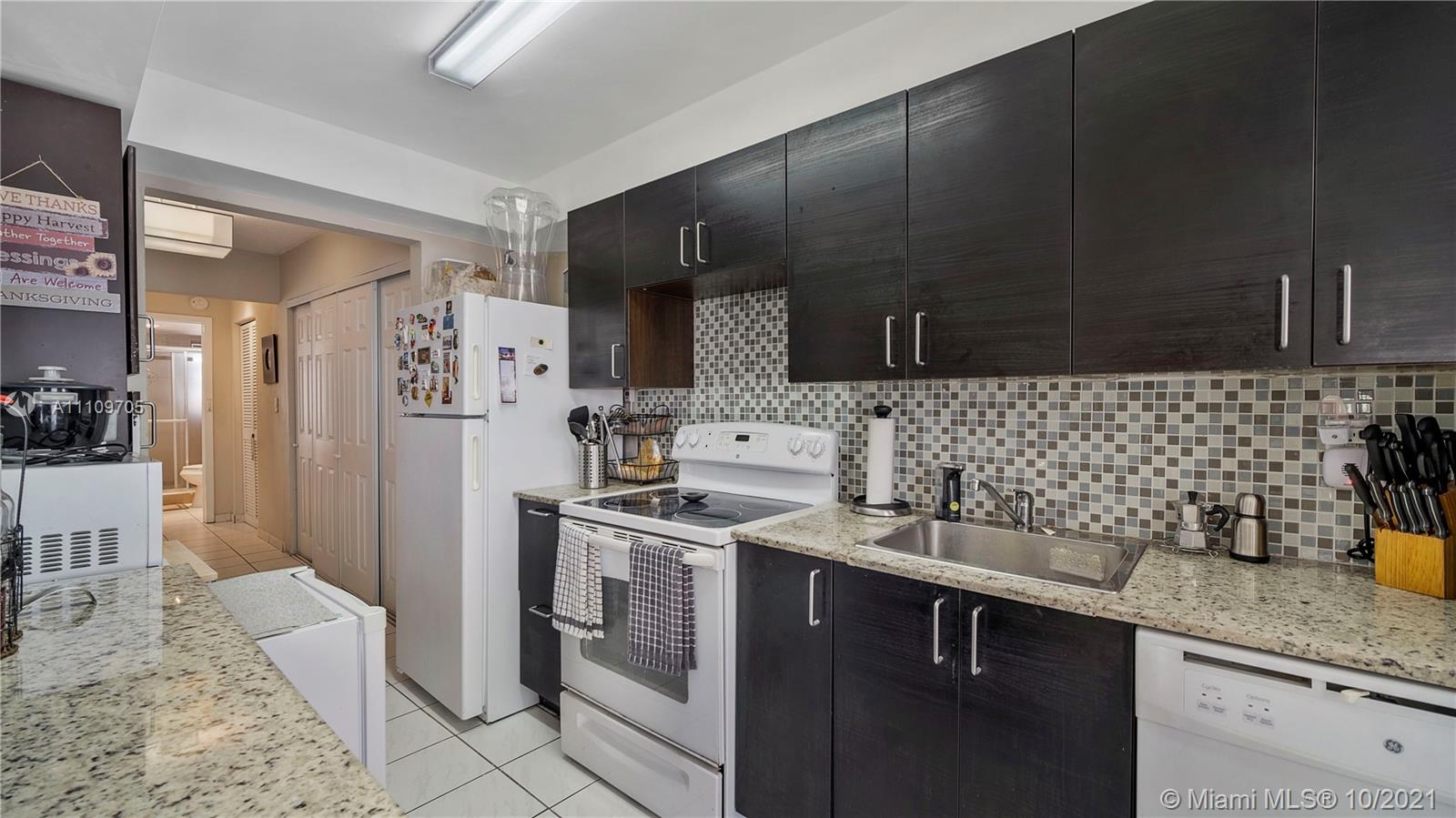 1340 Lincoln Road, Unit 806 Miami Beach, FL 33139 - Photo 12 of 48 a kitchen with stainless steel appliances a sink stove and refrigerator