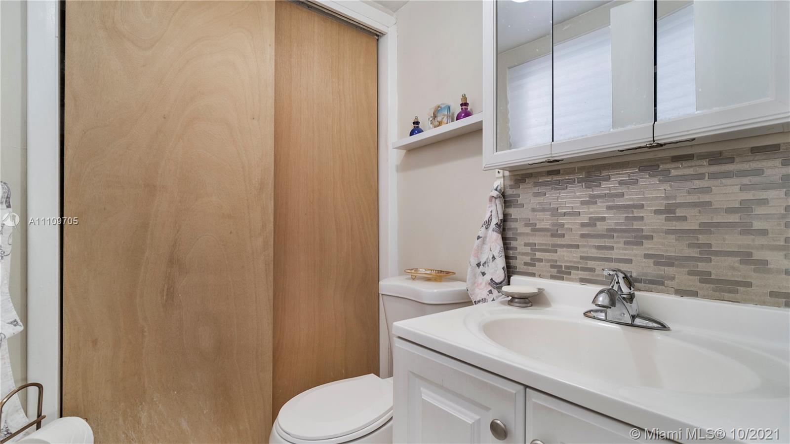 1340 Lincoln Road, Unit 806 Miami Beach, FL 33139 - Photo 19 of 48 a bathroom with a sink a toilet and mirror
