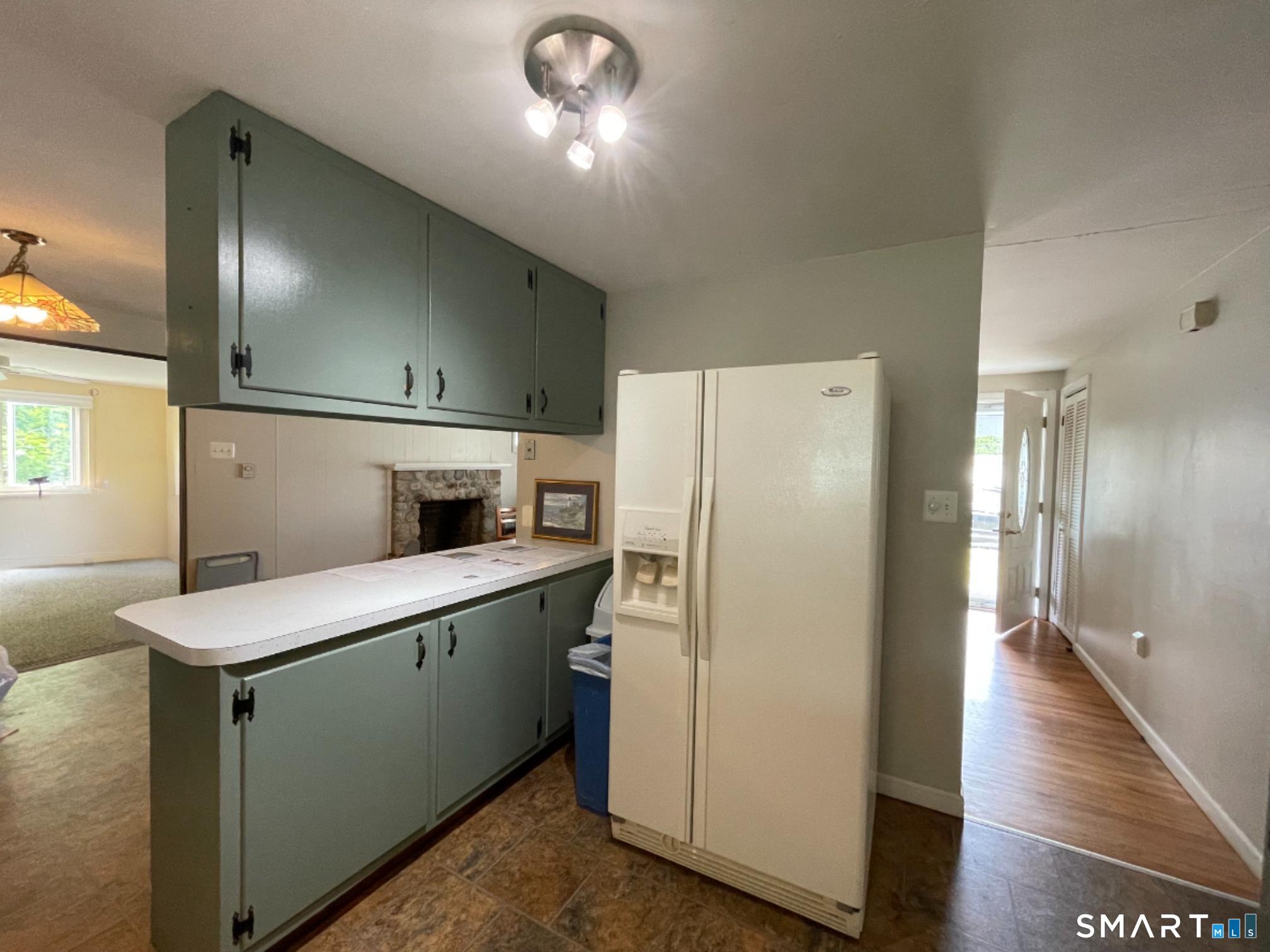 18 Old South Cove Road Old Saybrook, CT 06475 - Photo 18 of 40 a kitchen with a refrigerator sink and cabinets