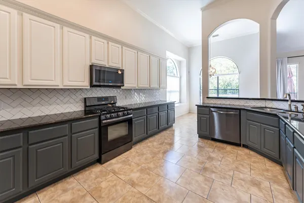 a kitchen with stainless steel appliances granite countertop a sink and stove top oven