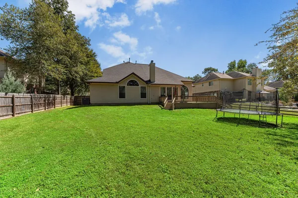 a view of a house with a big yard and large tree