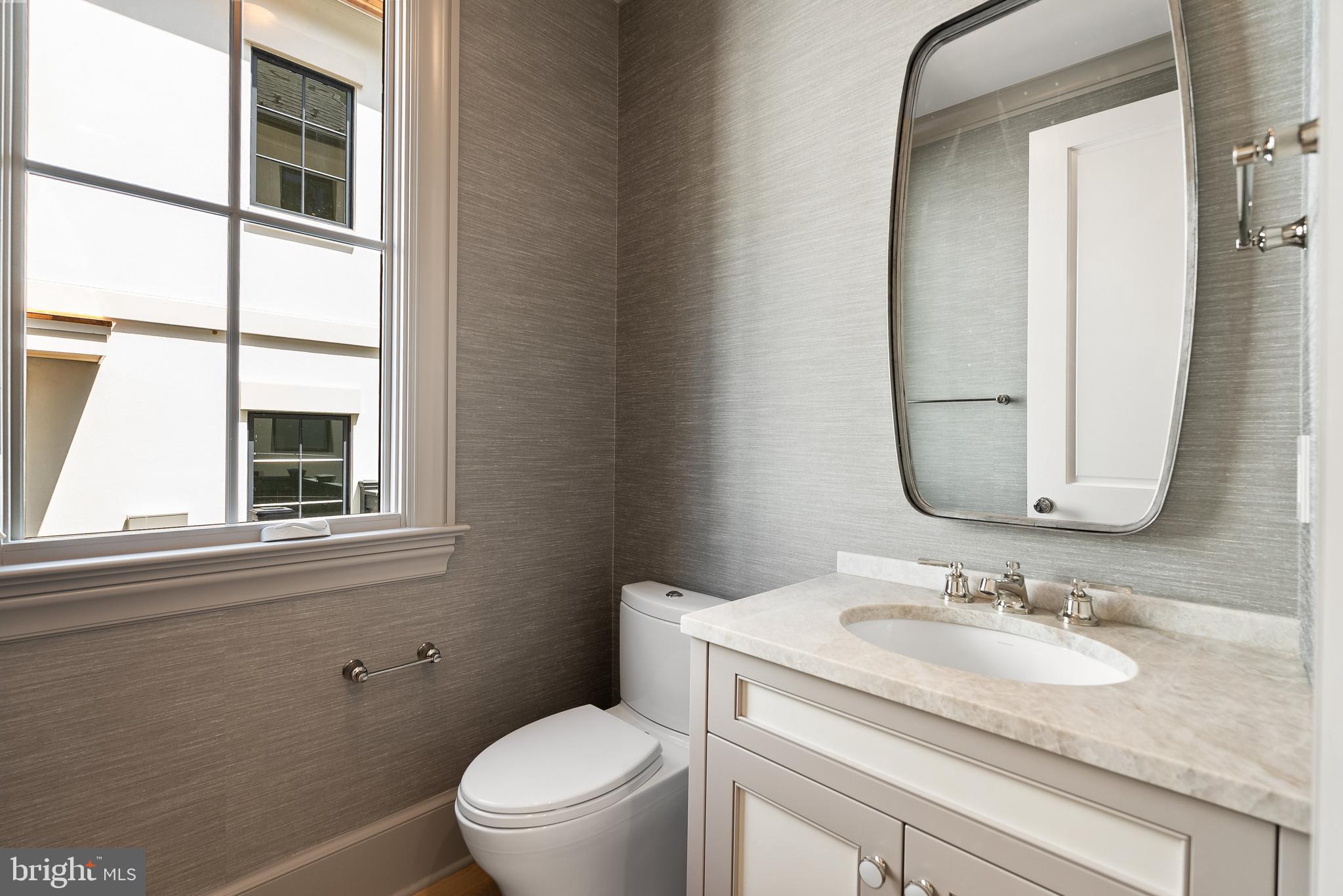 4905 Van Ness Street Northwest Washington, DC 20016 - Photo 14 of 27 a bathroom with a granite countertop toilet a sink and a mirror