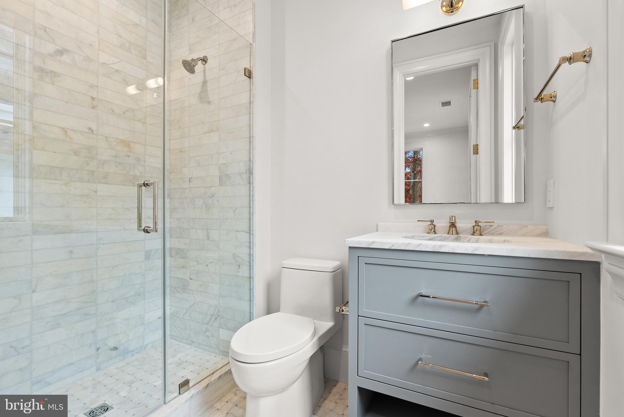 4905 Van Ness Street Northwest Washington, DC 20016 - Photo 20 of 27 a bathroom with a granite countertop toilet sink and a shower