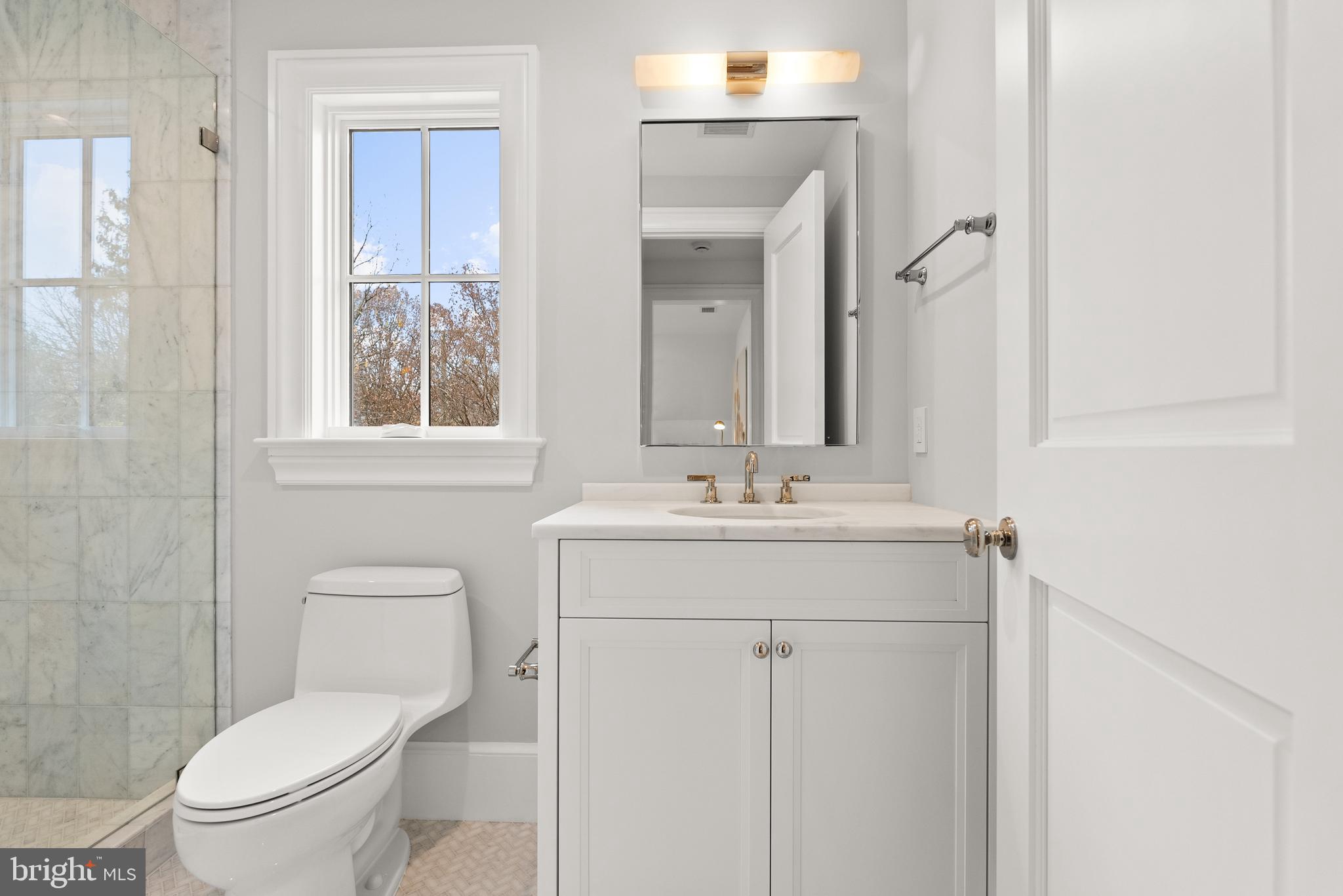 4905 Van Ness Street Northwest Washington, DC 20016 - Photo 24 of 27 a bathroom with a toilet sink and mirror