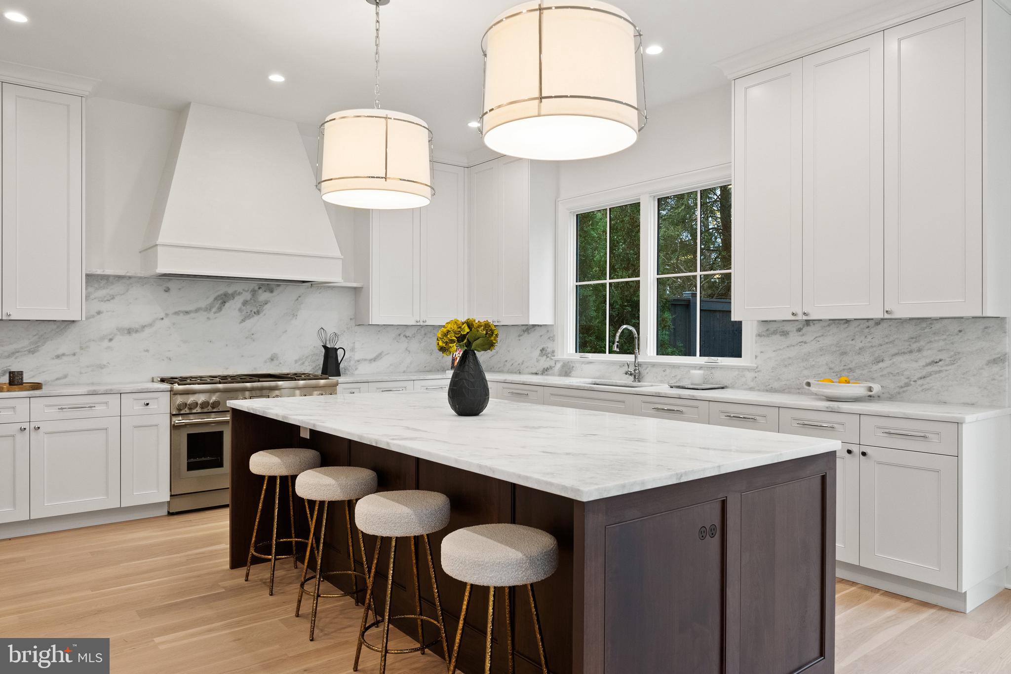 4905 Van Ness Street Northwest Washington, DC 20016 - Photo 4 of 27 a kitchen with a table a sink cabinets and wooden floor
